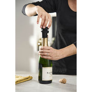 Peugeot | Preserve Champagne Stopper being used by a person to open a champagne bottle, highlighting its functionality in maintaining freshness.