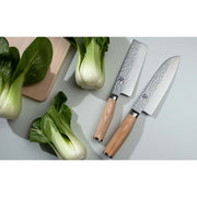 Shun Premier Blonde Nakiri, 5.5 knife with a hammered finish and blonde Pakkawood handle, displayed beside baby bok choy on a light wood cutting board.