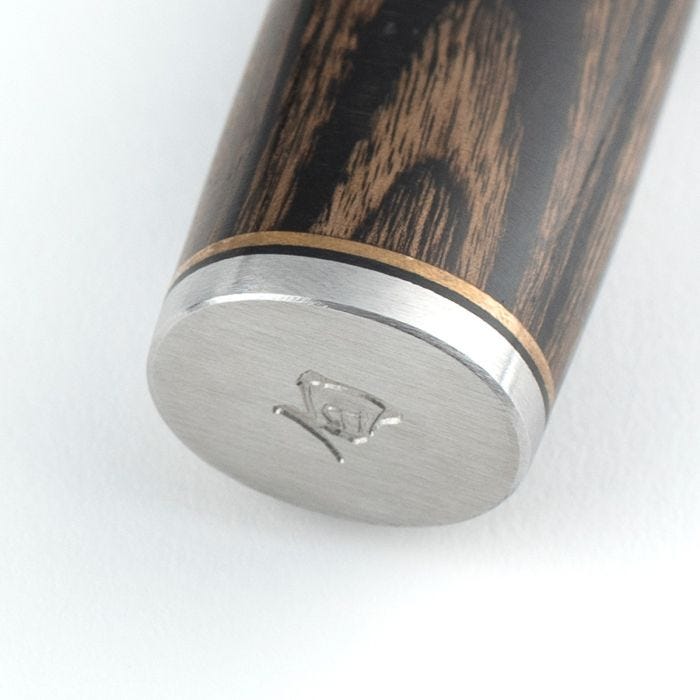 Close-up of the Shun Premier Nakiri Walnut 5.5 handle, featuring decorative brass and silver bands with a brushed-steel end cap engraved with a maker's mark.