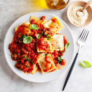 Marcato Ravioli Tablet Pasta Makers (Black) with ravioli on plate, showcasing ease of use for crafting perfect homemade ravioli.