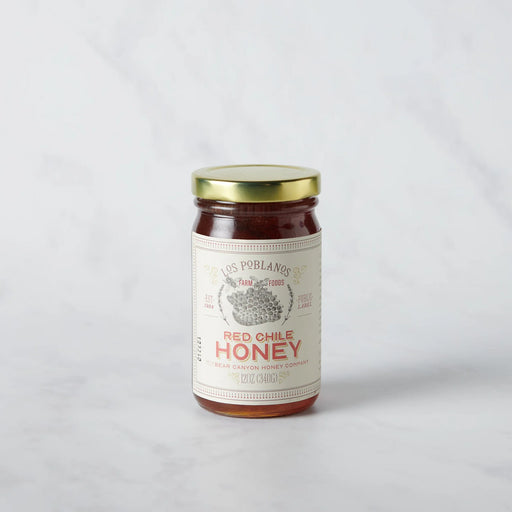 Los Poblanos | Red Chile Honey in a 12 oz glass jar with a gold lid, featuring a collaboration with Bear Canyon Honey Company.