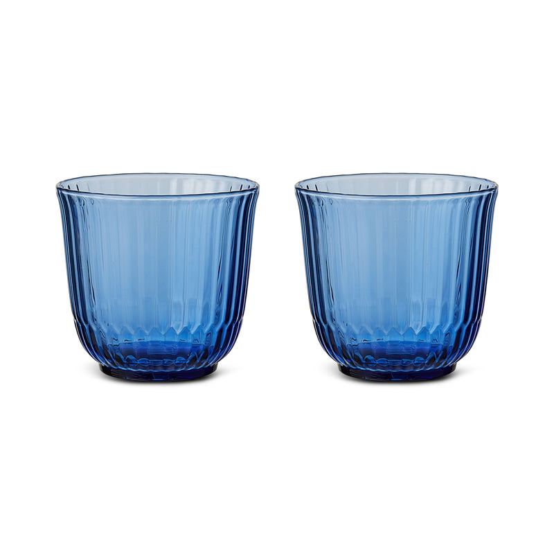Royal Copenhagen | Waves Water Glass, Blue, Set of 2 features translucent ribbed tumblers, inspired by ocean ripples, ideal for any table setting.