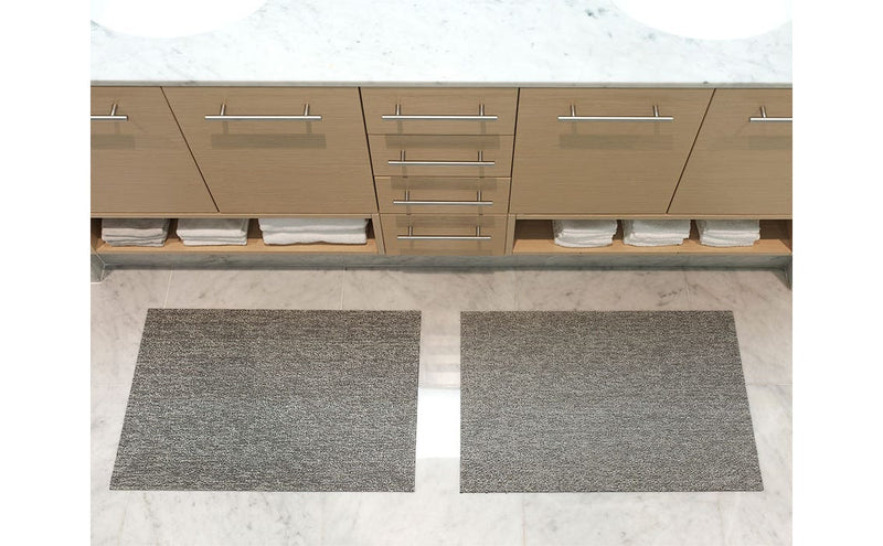 Chilewich Heathered Shag Mats in Fog on bathroom counter; durable, all-weather mat with plush texture and slip-resistant base, perfect for various spaces.