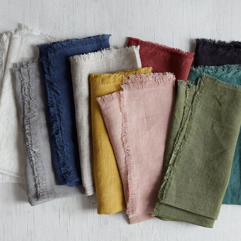 Sir|Madam | Linen Frayed Edge Napkins, Dove, Set of 4, displayed on a wooden surface, showcasing their simple elegance and practical design for versatile dining settings.