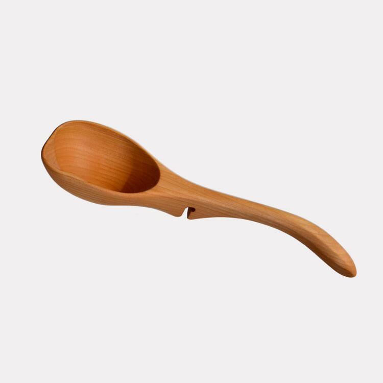 Jonathan's Cherry Wood Ladle from the Lazy Spoon® + Ladle Collection, designed for mess-free serving, elegantly rests on pots, enhancing any culinary setting.