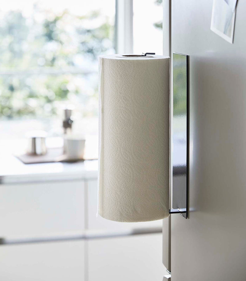 Yamazaki Home | Magnetic Steel Paper Towel Holder, White, elegantly mounted on a fridge, showcasing its minimalist design and space-saving functionality in a modern kitchen setting.