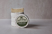Sweet Grass Dairy | Green Hill Cheese: A stack of round, soft-ripened white cheese wheels with a bloomy rind, reflecting artisanal Southern cheesemaking.