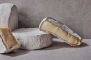 Sweet Grass Dairy | Green Hill Cheese, a soft-ripened, double-cream cheese with a bloomy rind, showcased close-up, highlighting its creamy texture and artisanal craftsmanship.