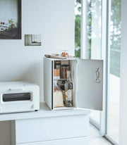Yamazaki Home | Bread Box, Vertical, Steel, Black holds bread inside a minimalist kitchen cabinet, enhancing decor and reducing clutter while ensuring optimal airflow.