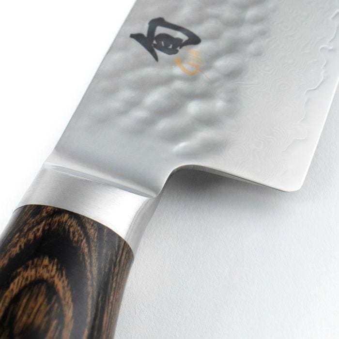 Shun Premier Santoku Walnut, 7, features a hammered tsuchime finish, Damascus pattern, kanji logo, and dark wood handle, highlighting its craftsmanship and versatility.