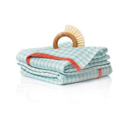 Caravan Home's 20 x 30 Gingham Aqua & Orange Towel with a wooden-handled scrubbing brush, showcasing a classic yet fresh kitchen accessory.