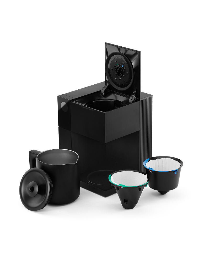 FELLOW | Aiden Precision Coffee Maker, Matte Black with a lifted lid, black carafe, and two reusable filter baskets for effortless, pour-over-style brewing.