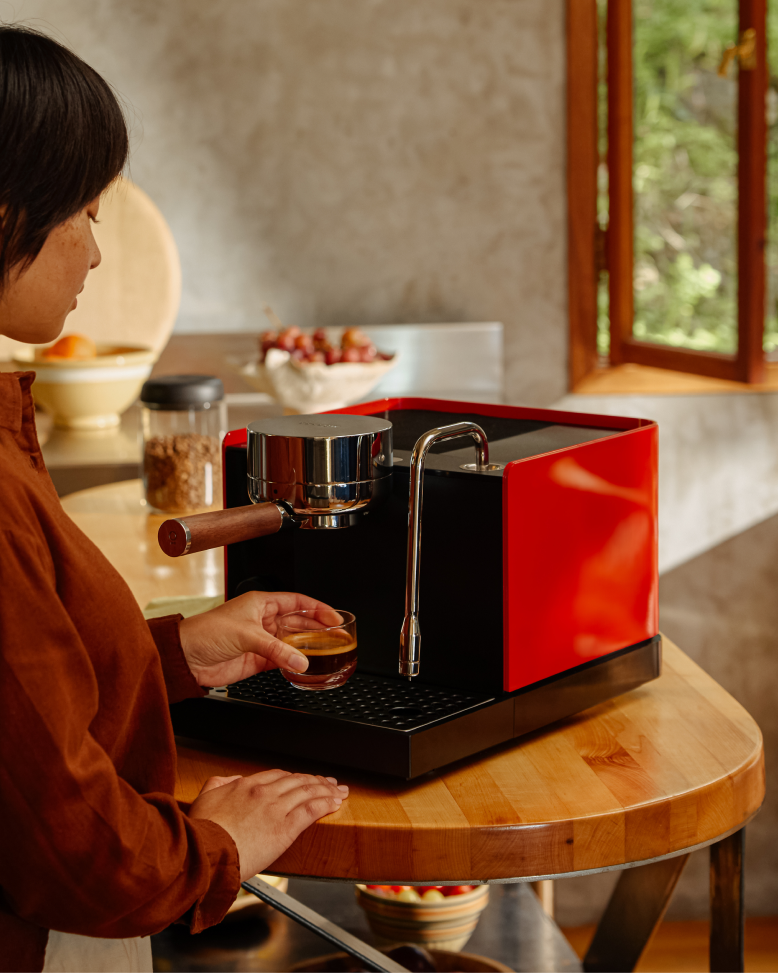 FELLOW | Espresso Series 1, Black, pulling a perfect espresso shot with precision on a compact machine in a sunlit kitchen, embodying professional home brewing.