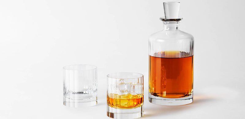 Richard Brendon | Fluted Large Decanter with amber spirit, matching stopper, and two rocks glasses, one filled with ice, reflecting an Art Deco-inspired design.
