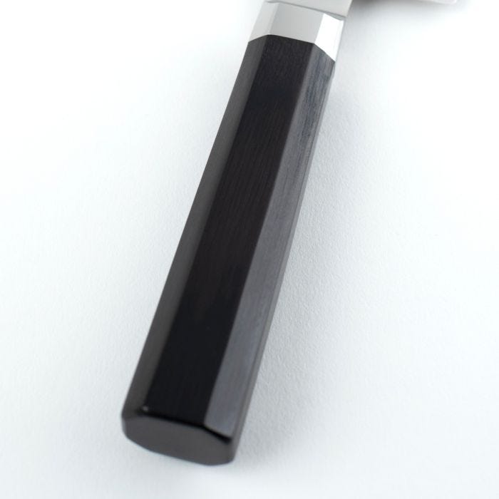 Close-up of Shun | Dual Core Nakiri's handle, featuring an octagonal ebony PakkaWood grip with polished metal ferrule, showcasing craftsmanship ideal for precise vegetable cutting.