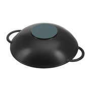 Staub Perfect Pan, a 14.5-inch matte black cast iron wok with a glass lid and metal rack, ideal for diverse cooking techniques.