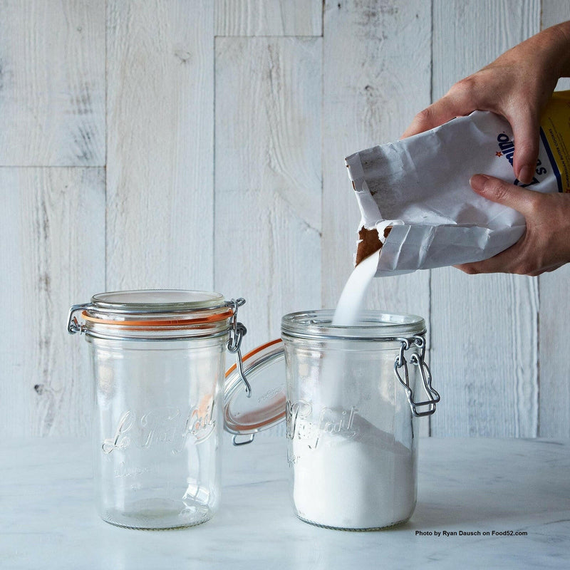 Le Parfait | Super Jars - 1L (32oz) with clamp-down lids; one jar being filled with sugar, exemplifying elegant, sustainable storage for kitchen staples.