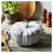 Staub Pumpkin Cocotte - White, cast iron pot inspired by Cinderella pumpkin, ideal for soups and casseroles, enhances any dining table with its whimsical design.
