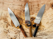 Rhymer Knives | 8 Chef Knives - African Blackwood + Rams Horn with Copper Bolster displayed on a wooden surface, showcasing hand-forged craftsmanship and superior handling design.