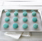 GIR | Baking Mat - Sprinkles - 9 x 12 displayed with blue macaroons, highlighting its use for baking delicate desserts.
