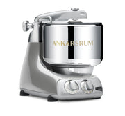 Ankarsrum Assistent Original stand mixer with a silvery finish, featuring a stainless-steel mixing bowl and dual control knobs, ideal for heavy dough mixing.