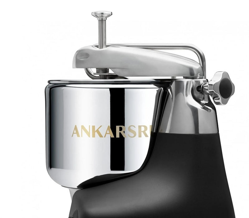 Ankarsrum | Stand Mixers in Store - Cloudy Pink: Sleek stainless-steel bowl and locking arm on a black base, showcasing the brand's robust design for versatile kitchen use.