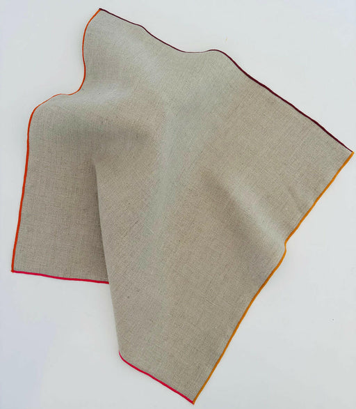 Tisch New York | Natural Linen Napkins Set of 4 - Pink Hem, featuring beige fabric with a red-edged design, ideal for elegant dining settings.
