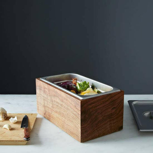 Alabama Sawyer | Noaway Countertop Compost Bins - Original Countertop Compost Bin - Walnut | Clear Oil, displayed on a cutting board, featuring a wooden design for eco-friendly kitchen use.