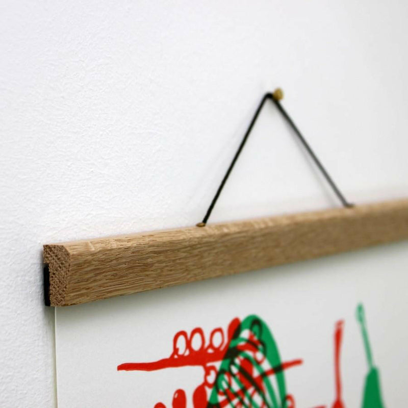 Earth & Nest | Oak Poster Hanger - Large, featuring magnetic grips and a fixed cord, elegantly displays posters without adhesive, perfect for home or office décor.