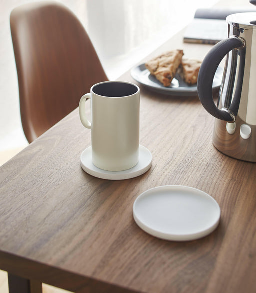 Yamazaki | Tower Silicon Coaster sits on a wooden table beside a ceramic mug and kettle, embodying minimalist Japanese design.