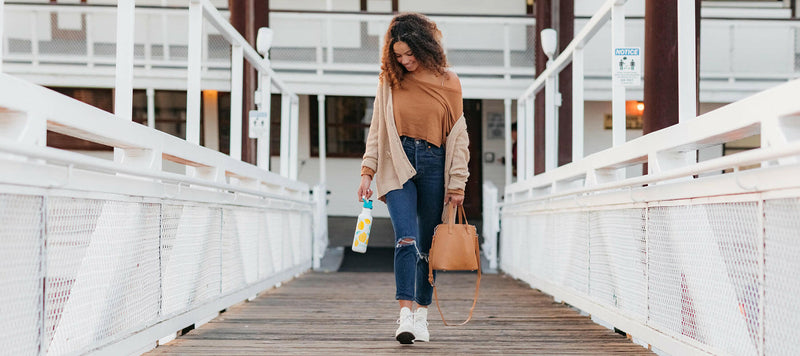 Klean Kanteen 27oz Classic Water Bottle with Sport Cap held by woman, ideal for active lifestyles and easy hydration on the go.