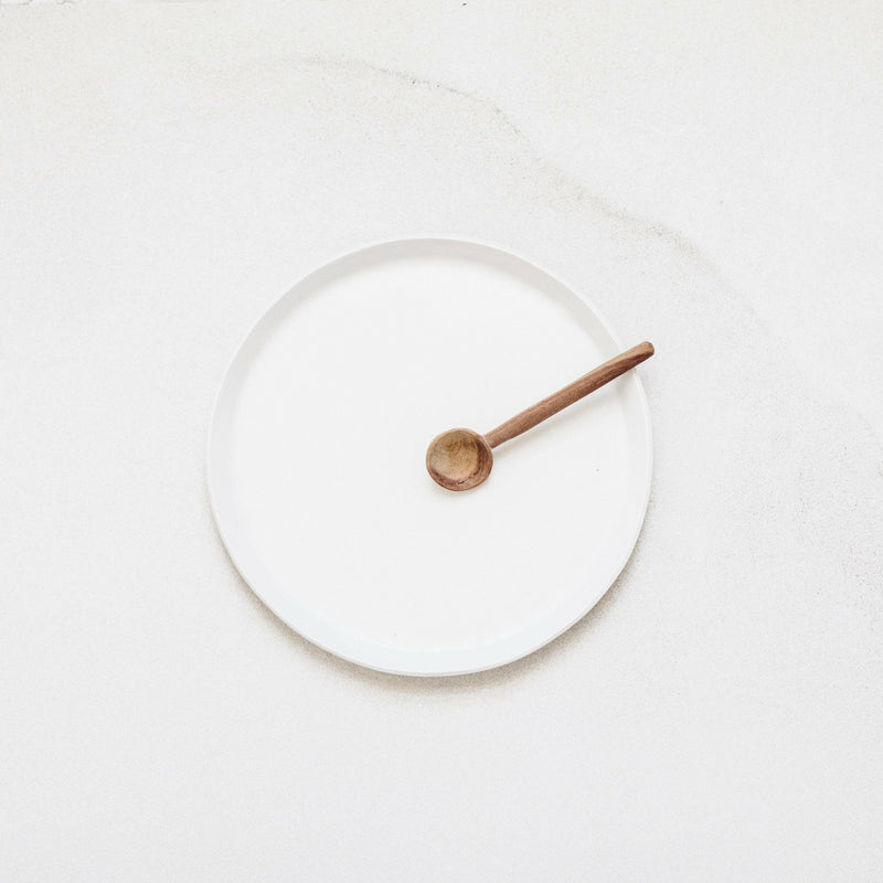 Looks Like White | Scandi Cereal Bowl on a white surface, featuring a small wooden spoon, exemplifying minimal elegance and handcrafted design by Trudy Crane.