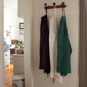 Sir|Madam Linen Grand Apron - Faded Black hanging neatly, showcasing adjustable neck loop, side-vents, and waist-level pockets, ideal for kitchen enthusiasts at Athens Cooks.